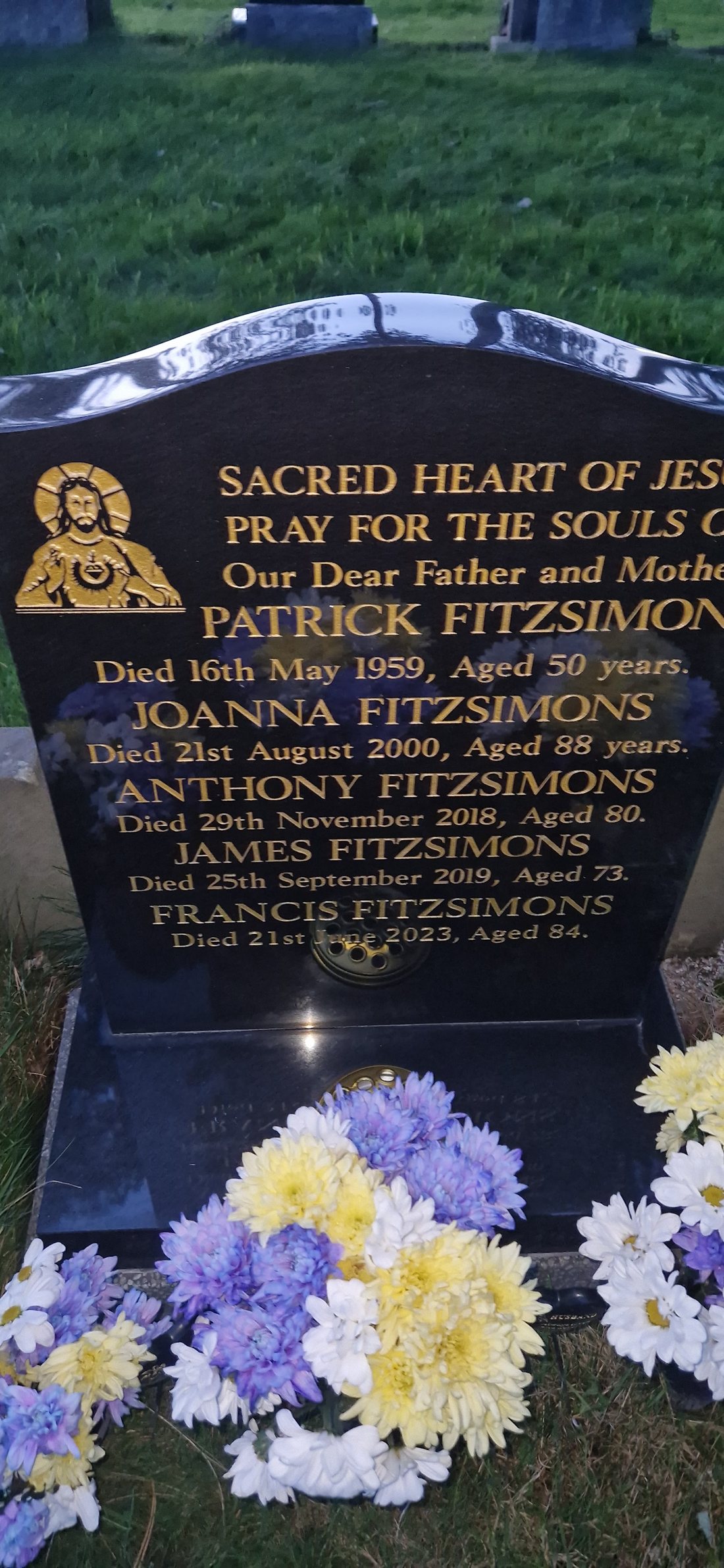 A black granite headstone with gold leaf lettering, made by Evans & Burkey